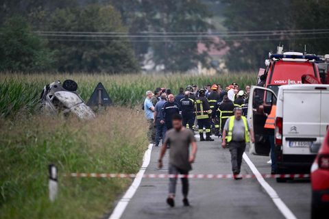 Polizisten und Rettungskräfte stehen neben dem Wrack des Autos bei Turin in Italien