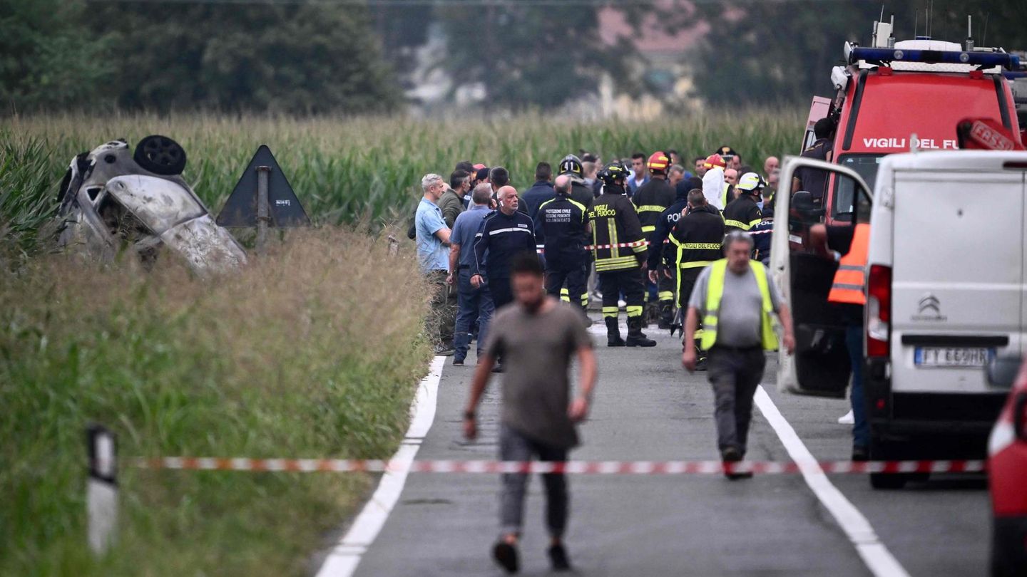 Polizisten und Rettungskräfte stehen neben dem Wrack des Autos bei Turin in Italien