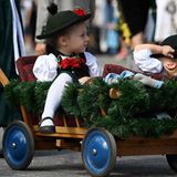 So viele Menschen machen müde. Einer der beiden kleinen Trachtenumzügler  hat sich den Hut übers Gesicht gezogen und macht ein Nickerchen.