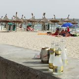 Leere Sektflaschen an einem Strand auf Mallorca