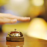 Hand haut auf eine Klingel na einer Rezeption