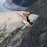 Zwei Frauen sitzen auf der Trolltunga in Norwegen