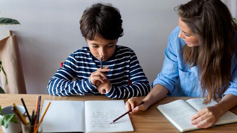 Ein Schüler macht mit seiner Mutter zusammen Hausaufgaben