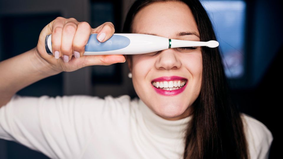 Deals & Angebote der Woche: Frau hält sich Elektrische Zahnbürste vor die Augen