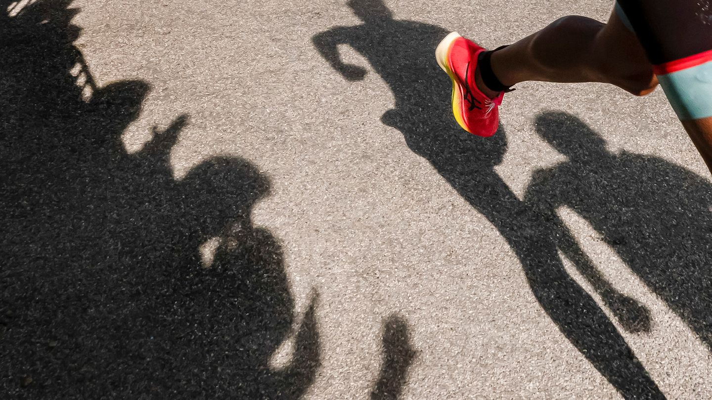 Der Schatten eines Läufers auf dem Weg zur Ziellinie