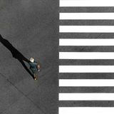 Ein Mann geht an einem Zebrastreifen entlang.