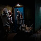 Köche stehen nachts im Schummerlicht vor einem Gebäude und machen Pause