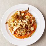 Gerösteter Blumenkohl, gemogelte Romesco-Sauce & zerstoßene geröstete Mandeln  Das Leben ist schöner mit Romesco-Sauce! Ob zu leckerem Gemüse genossen, wie diesem Blumenkohl, zu Fisch, Geflügel oder Lamm – sie macht Freude, bei der Zubereitung wie auf dem Teller.  Für 4 Personen. Fertig in 45 Minuten  Zutaten:  1 Blumenkohl (800 g), 4 Knoblauchzehen, 100 g helles Sauerteigbrot, 50 g blanchierte Mandeln, 1 Glas geröstete rote Paprikaschoten in Lake (460 g)  Zubereitung:  Den Backofen auf 180 °C vorheizen. Nur die äußeren welken Blätter des Blumenkohls entfernen und den Strunk etwas kürzen. Den Blumenkohl halbieren, in 3cm dicke Spalten schneiden und in einer großen ofenfesten Form in etwas Olivenöl und Rotweinessig wenden. Mit Meersalz und schwarzem Pfeffer würzen und im Ofen 35 Minuten rösten, bis der Blumenkohl goldbraun und durchgegart ist. Inzwischen den Knoblauch schälen, das Brot in Stücke zupfen und mit den Mandeln in einer zweiten ofenfesten Form verteilen. 15 Minuten, bevor der Blumenkohl fertig ist, die zweite Form ebenfalls in den Ofen schieben.  Sobald die Garzeit beendet ist, beide Formen aus dem Ofen nehmen. Eine Handvoll Mandeln beiseitelegen, den Rest mit dem Knoblauch und dem gerösteten Brot in den Mixer geben. Die abgetropften Paprikaschoten sowie 2 EL Olivenöl und 1 Schuss Rotweinessig hinzufügen und mixen, bis die Sauce glatt und seidig ist. Falls nötig, mit einem Schuss Wasser verdünnen und sorgfältig abschmecken. Die Sauce auf eine Platte gießen und den Blumenkohl darauf anrichten. Die restlichen Mandeln zerstoßen oder hacken, den Blumenkohl damit bestreuen und servieren.