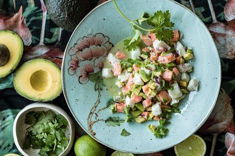 Ceviche mit Lachs peruanische Art auf einem Teller mit Avocados und Limetten daneben
