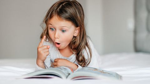 Deutscher Kinderbuchpreis 2023: Mädchen schaut begeistert in ein Buch