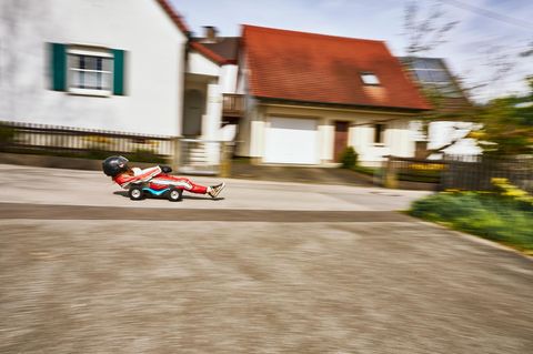 Junge Frau rast auf ihrem Bobby-Car vorbei