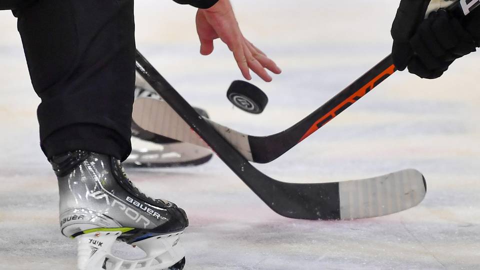Eishockeyschläger ringen um den Puck auf dem Eis