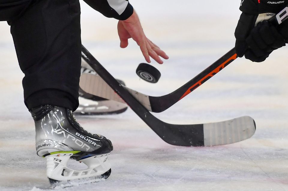 Eishockeyschläger ringen um den Puck auf dem Eis