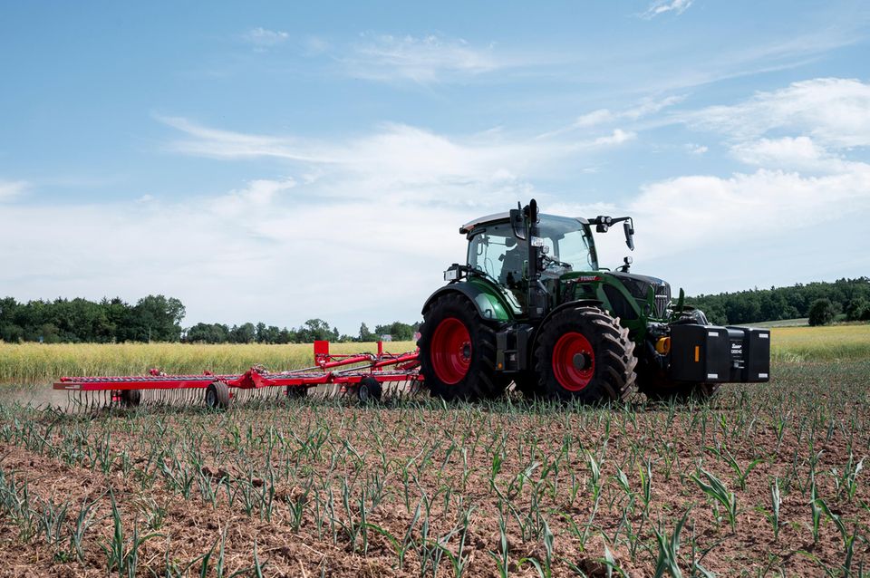 Ein Traktor fährt über einen Acker Ein Traktor fährt über einen Acker