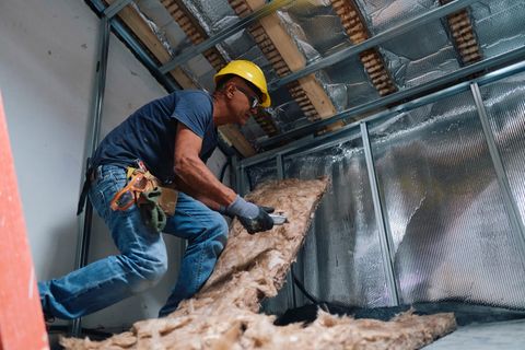 Handwerker bringt Dämmmaterial an