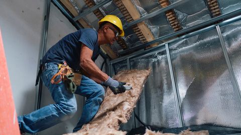 Handwerker bringt Dämmmaterial an