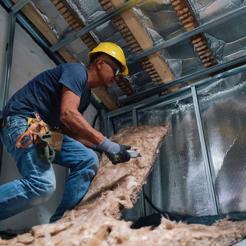 Handwerker bringt Dämmmaterial an