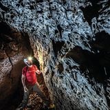 Mann mit rotem T-Shirt und brauner Hose in einer Höhle