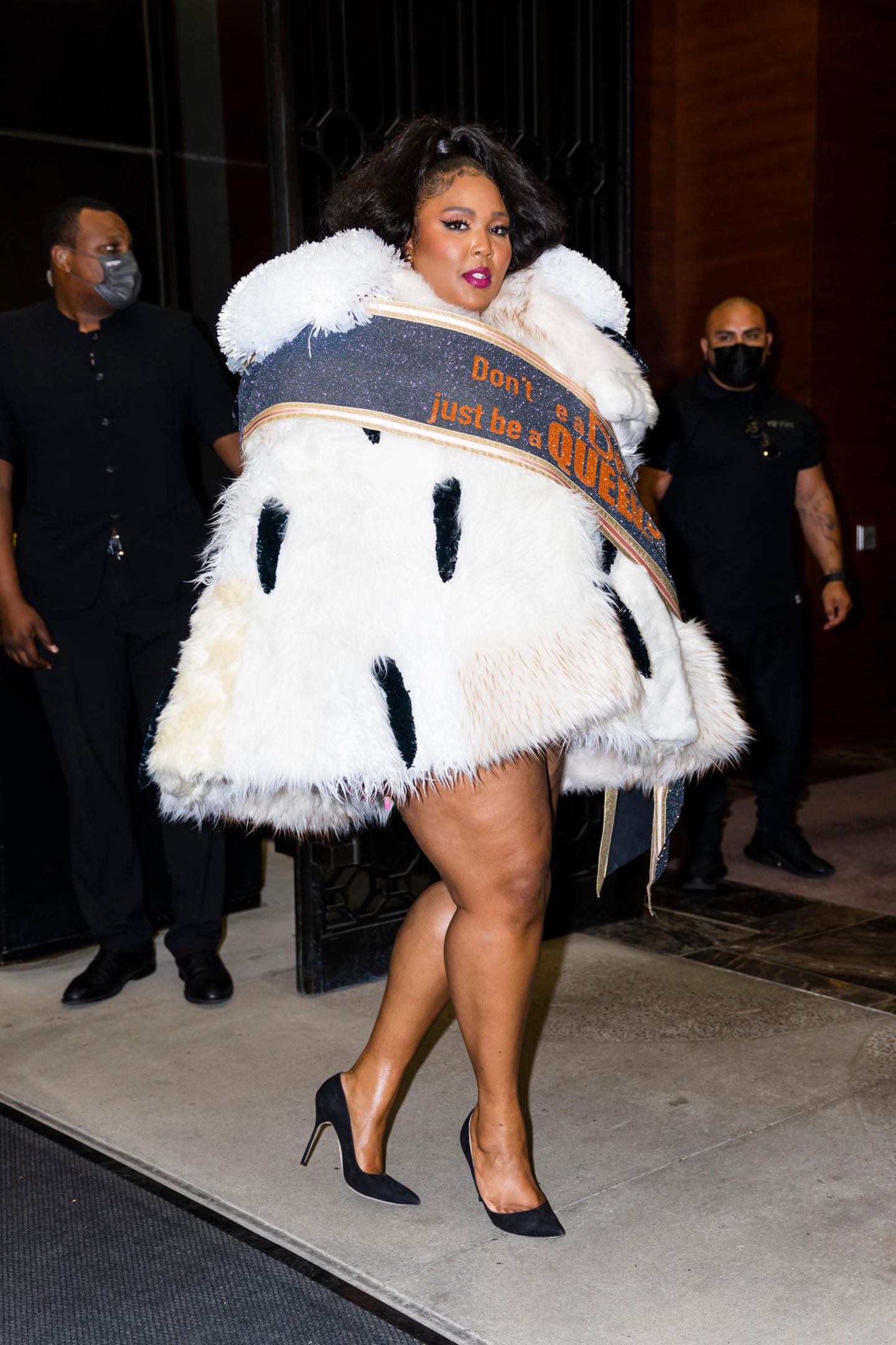 Lizzo in einem nachgemachten Hermelin mit Schärpe darüber