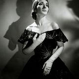 Maria Callas im schwarzen Abendkleid blickt sehnsüchtig in die Ferne