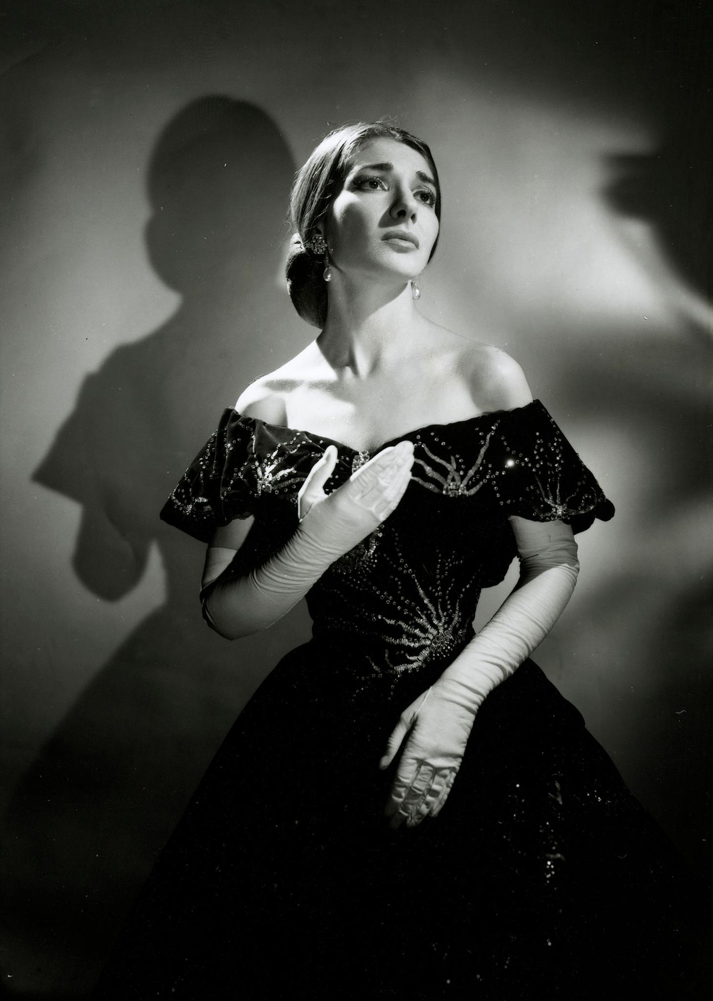 Maria Callas im schwarzen Abendkleid blickt sehnsüchtig in die Ferne