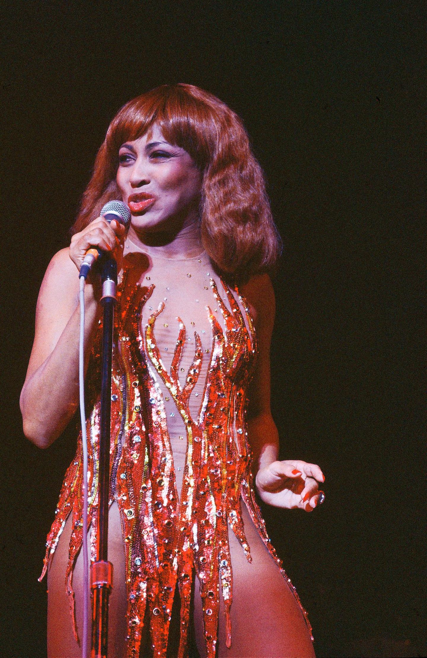 Tina Turner 1980 in einem roten Flammenkleid auf der Bühne