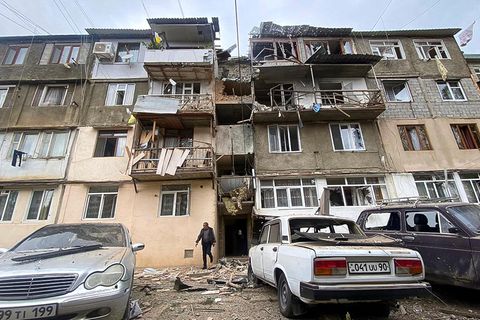 In Berg-Karabach kommt ein Mann aus dem Eingang eines zerstörten Wohnhauses
