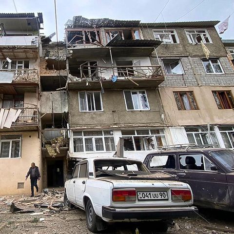 In Berg-Karabach kommt ein Mann aus dem Eingang eines zerstörten Wohnhauses