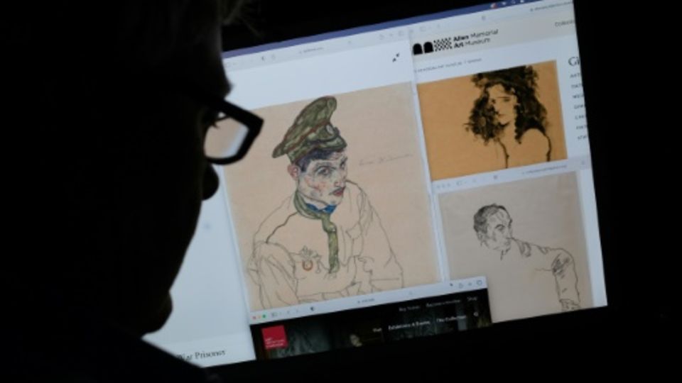 Ein Mann schaut sich Zeichnungen von Egon Schiele auf einem Computer an