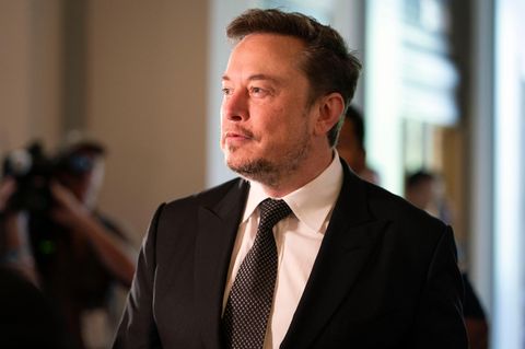Elon Musk im Anzug im Seitenprofil