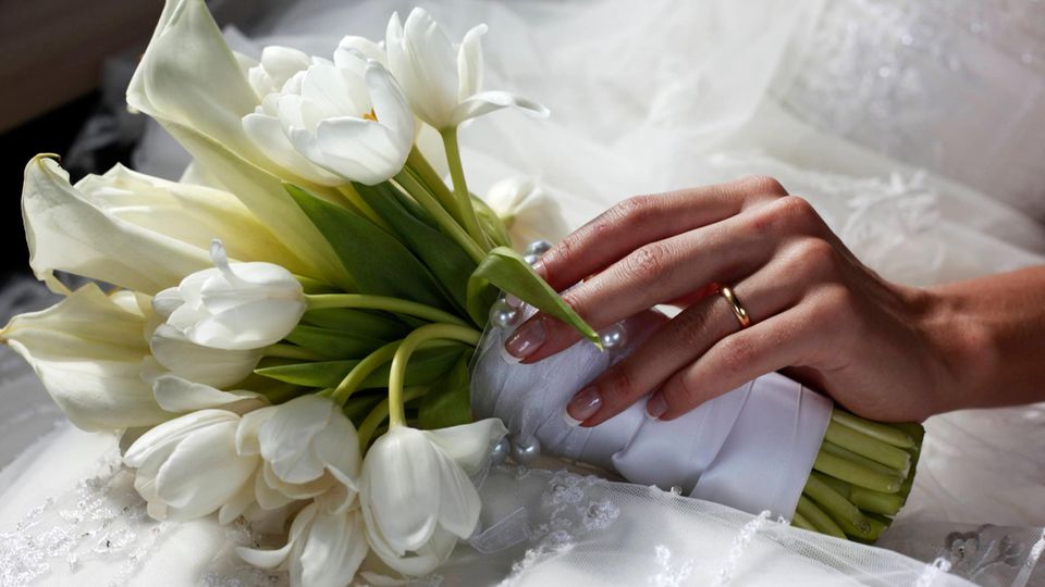 Braut hält einen Strauß mit Fotos