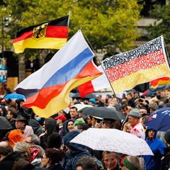 Aus einer Menschenmenge auf einer Demo in Hannover wehen deutsche Flaggen und eine russische