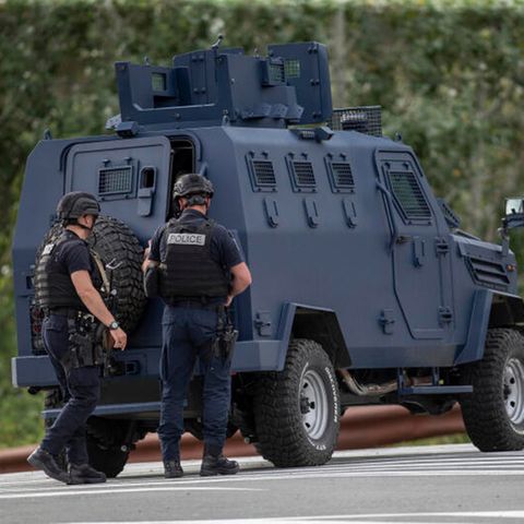 Drei Polizisten aus dem Kosovo sichern eine Straße, die zum belagerten Kloster führt