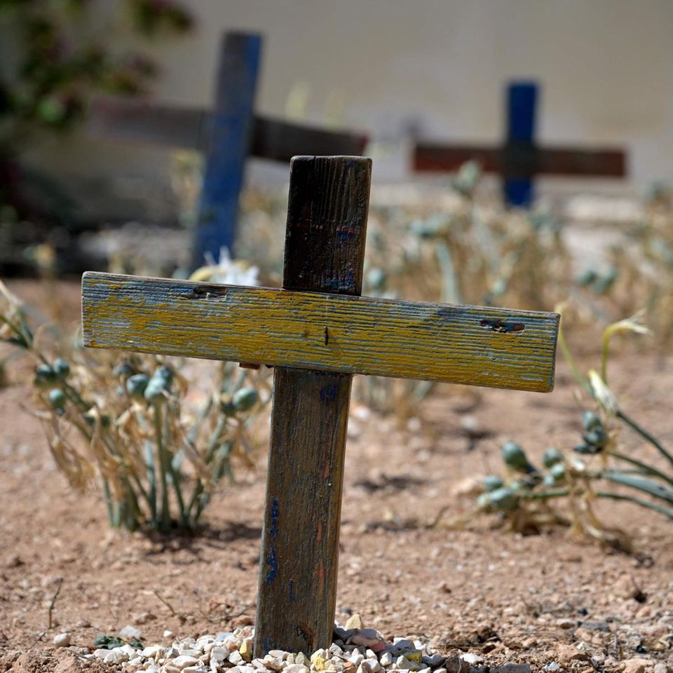 Ein kleines Holzkreuz auf einem Friedhof