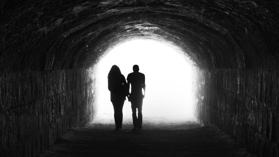 Umriss einer Frau und eines Mannes in einem Tunnel