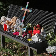 Trauernde haben auf einer Bank an einem See in Pragsdorf unter anderem Kerzen, Blumen und Plüschtiere abgelegt