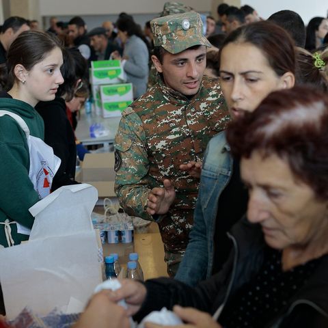 Armenien, Goris: Ethnische Armenier aus Bergkarabach warten in einem provisorischen Lager auf humanitäre Hilfe. Nach dem Angriff auf das Gebiet durch Aserbaidschan fliehen immer mehr Menschen nach Armenien
