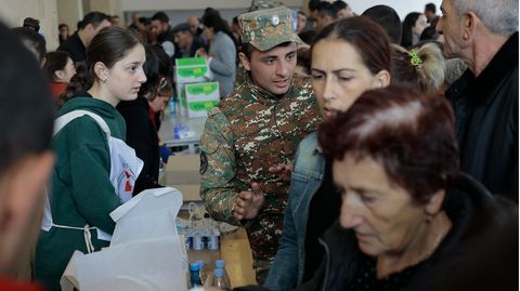 Armenien, Goris: Ethnische Armenier aus Bergkarabach warten in einem provisorischen Lager auf humanitäre Hilfe. Nach dem Angriff auf das Gebiet durch Aserbaidschan fliehen immer mehr Menschen nach Armenien