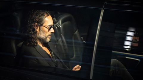 Russell Brand sitzt mit Sonnenbrille in einem dunklen Auto