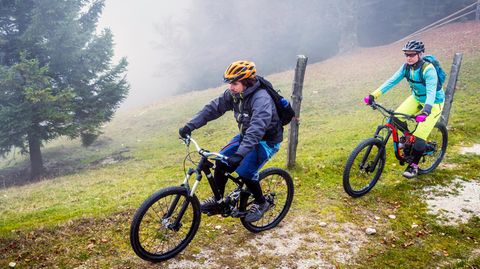 Regenbekleidung fürs Radfahren: Zwei Mountainbiker in herbstlichen Bergen