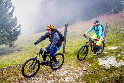 Regenbekleidung fürs Radfahren: Zwei Mountainbiker in herbstlichen Bergen