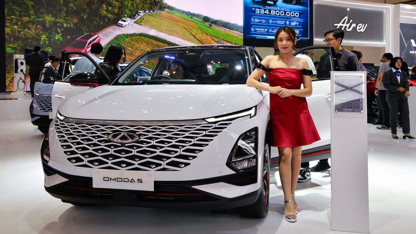 Eine Frau steht neben dem Omoda 5 des China-Herstellers Chery