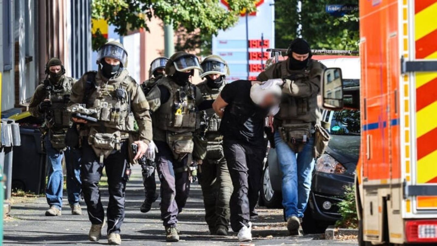 Spezialkräfte der Polizei führen einen Verdächtigen ab