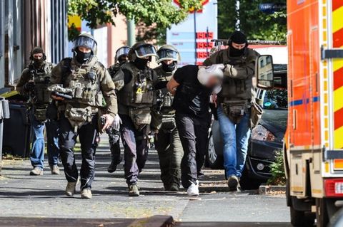 Spezialkräfte der Polizei führen einen Verdächtigen ab