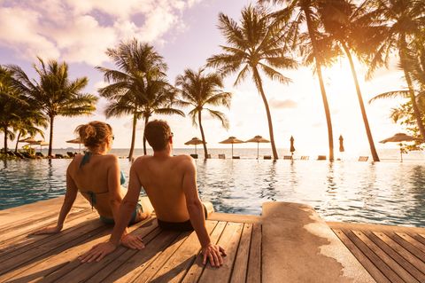 Symbolfoto für Brückentage 2024: Ein Paar sitzt an einem Pool
