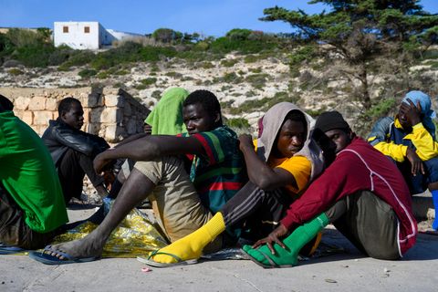 Auf Lampedusa angekommene Geflüchtete warten auf ihre Registrierung