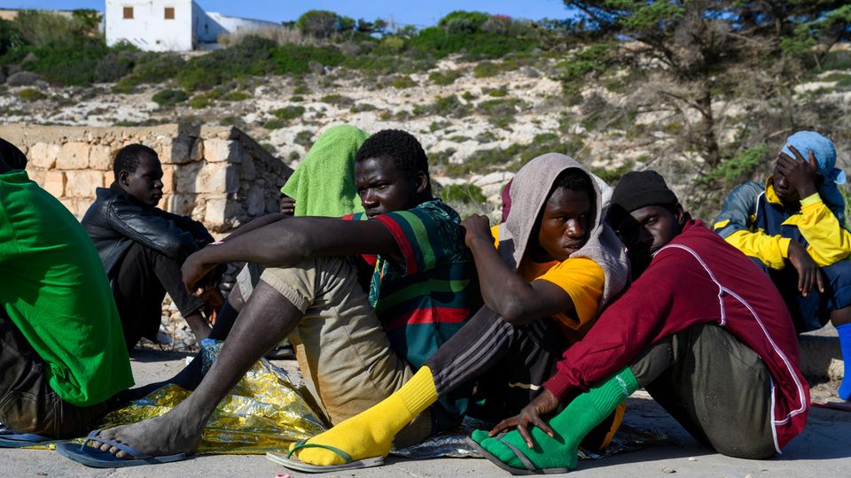 Auf Lampedusa angekommende Geflüchtete warten auf ihre Registrierung