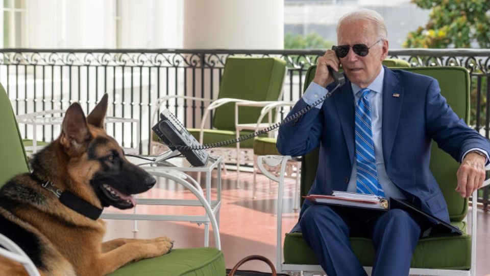 US-Präsident Joe Biden telefoniert auf dem Truman-Balkon im Weißen Haus, während sein Hund Commander neben ihm auf dem Sofa liegt