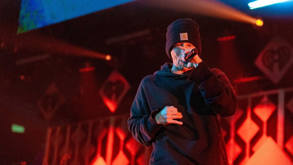 Rapper NF mit einem Mikro in der Hand