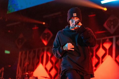 Rapper NF mit einem Mikro in der Hand
